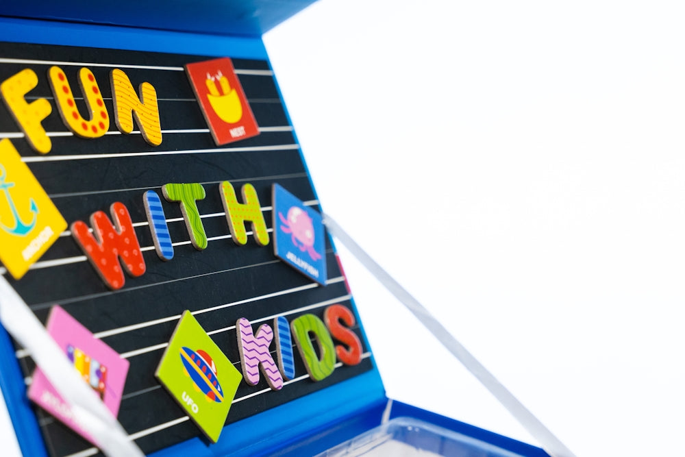 un tableau avec des aimants sur lesquels sont inscrits le mot « amusant » pour les enfants