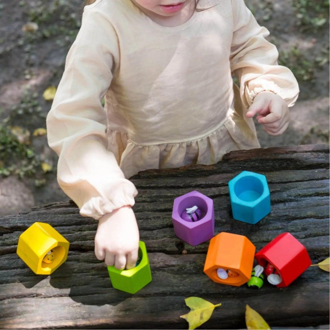 Bambina che gioca con le api nell'alveare, posizionando ogni ape nel suo favo corrispondente