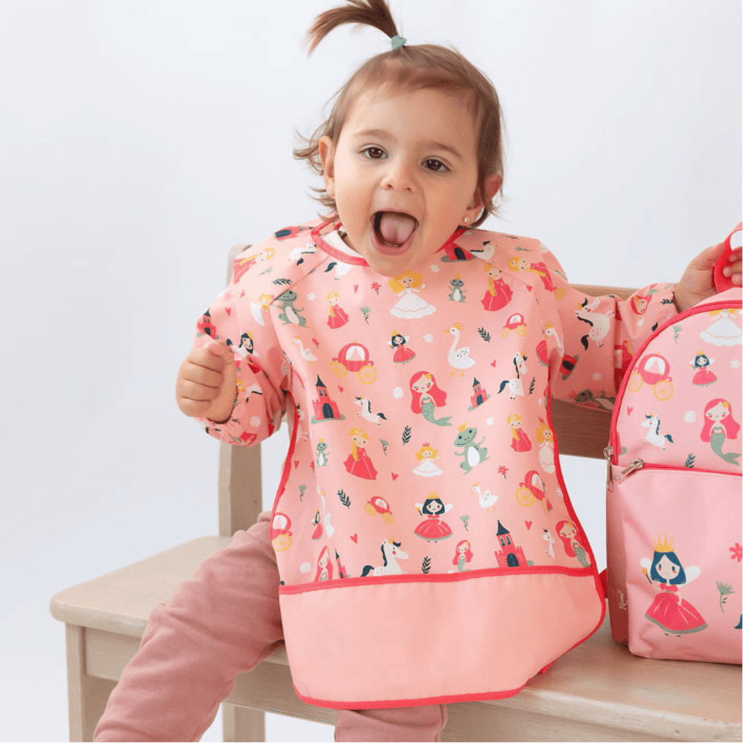 Bambina con bavaglino impermeabile a maniche lunghe con stampa principessa