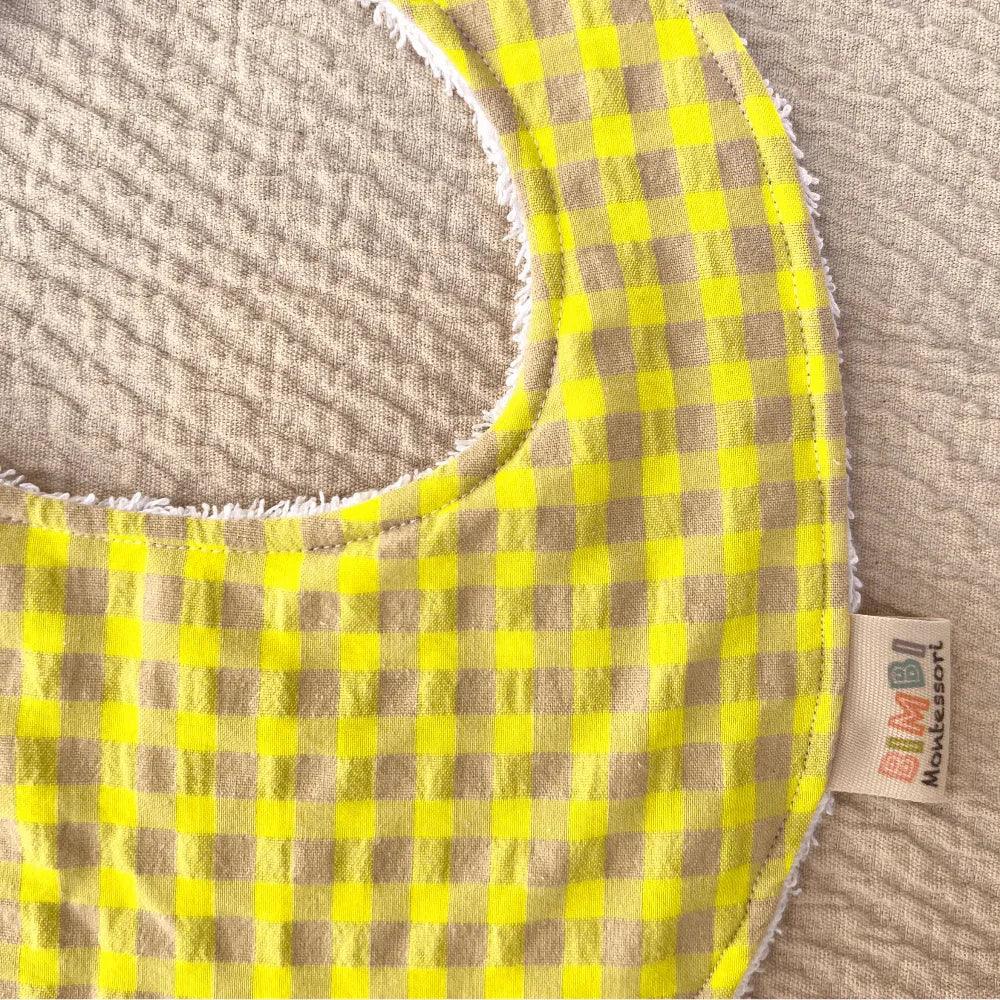 Bavaglino per neonati con stampa a quadretti gialli e beige, design morbido e assorbente di Bimbi Montessori
