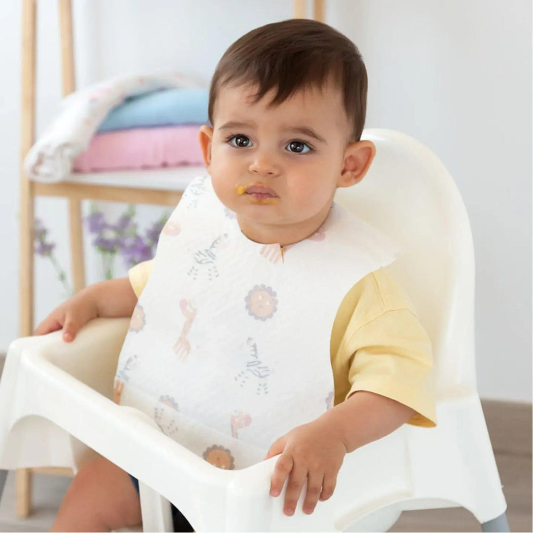 Un bambino indossa un bavaglino usa e getta con una stampa di animali durante i pasti.
