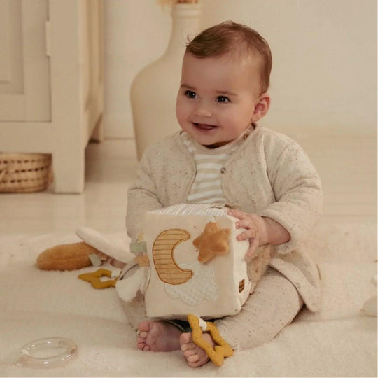 Bambino che gioca con il cubo sensoriale Little Dutch nei toni del beige e della crema, ideale per l'esplorazione tattile.