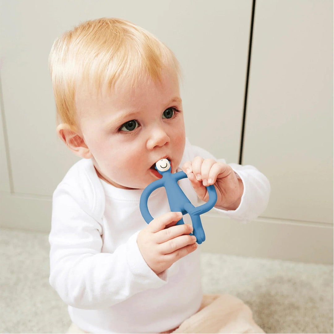 Bébé utilise un anneau de dentition en silicone bleu marine Matchstick Monkey pour apaiser ses gencives pendant la poussée dentaire