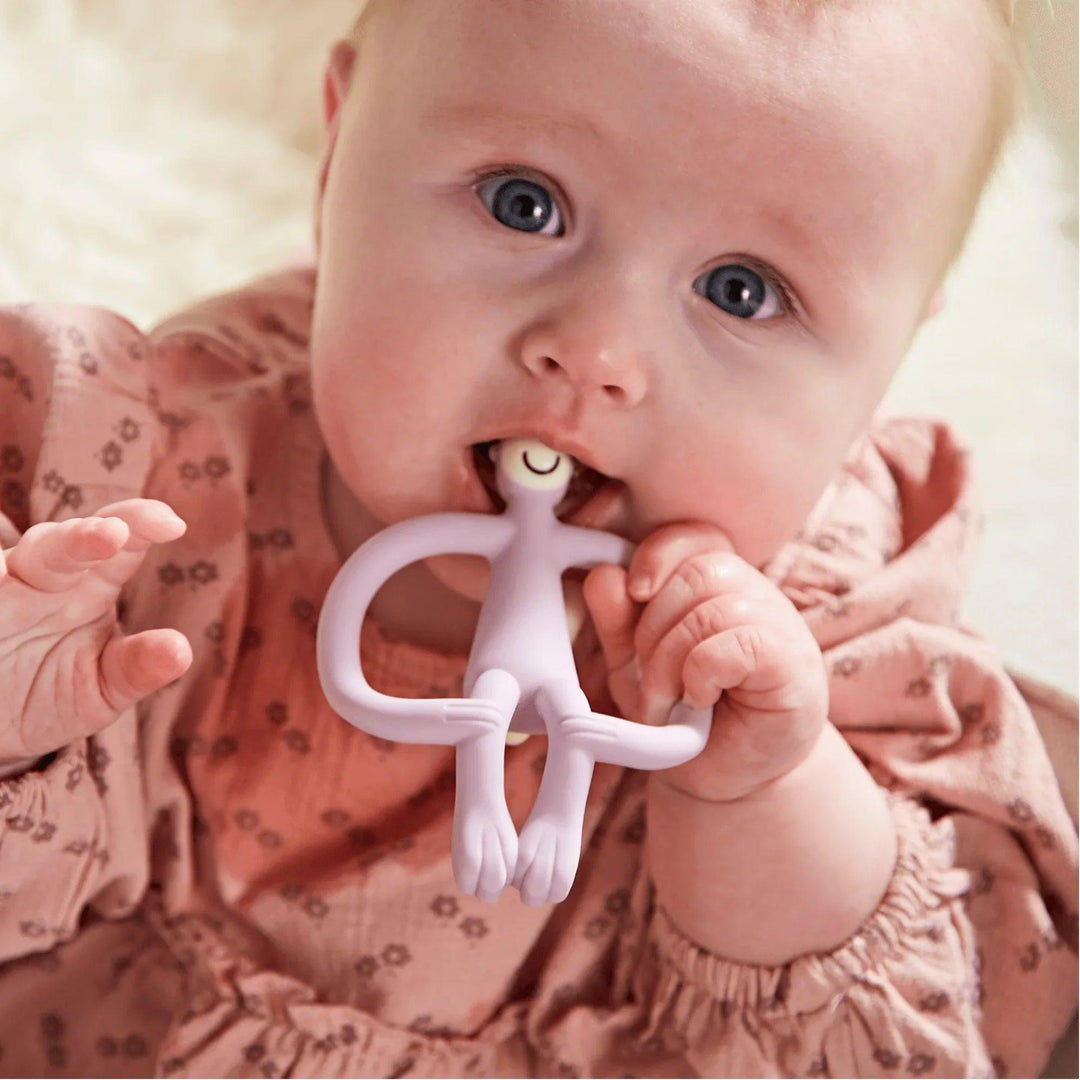 Bébé utilise un anneau de dentition en silicone Matchstick Monkey de couleur lilas pour soulager les poussées dentaires
