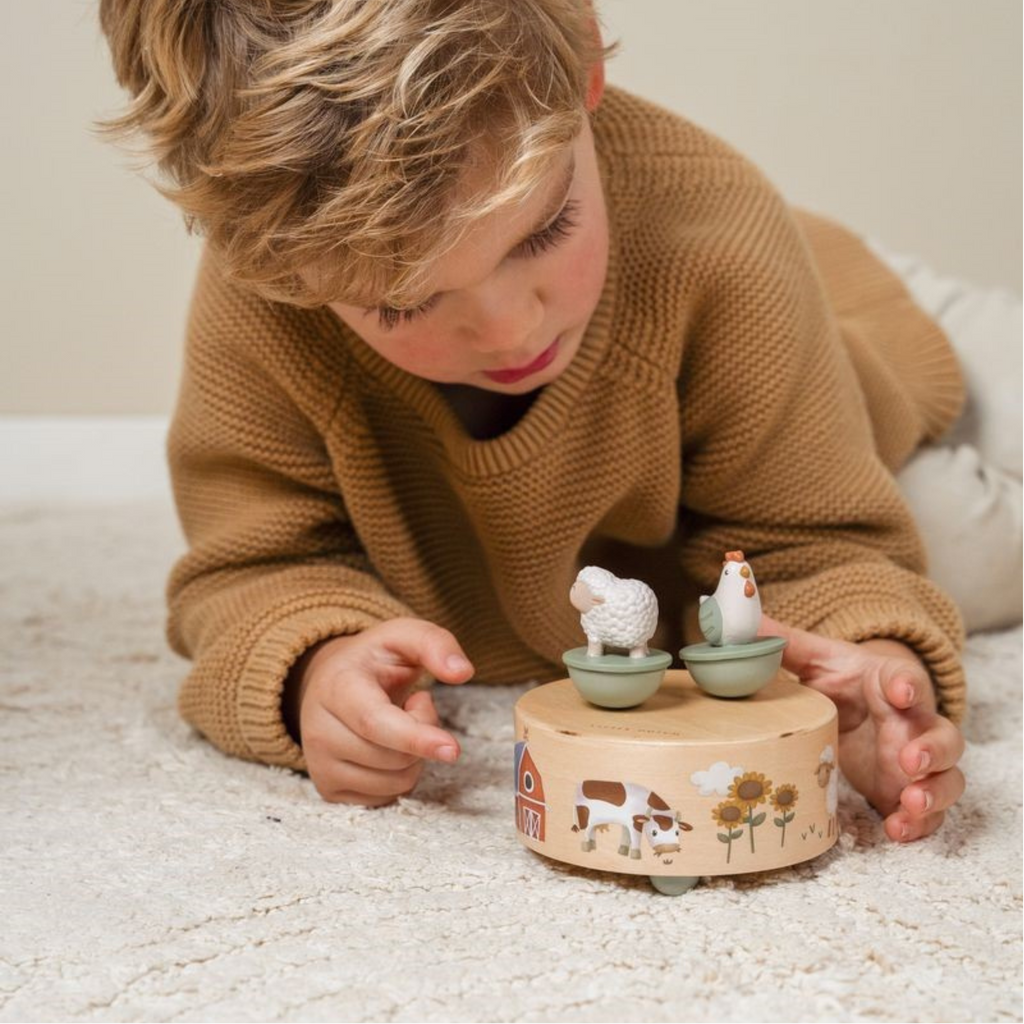 Caja musical de madera con temática de granja, incluye figuras de animales que giran al ritmo de la música, ideal para niños