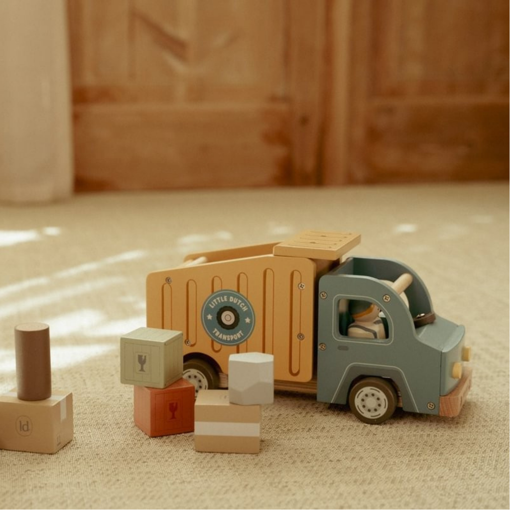 Camión de reparto de madera Little Dutch con bloques de carga de colores sobre una alfombra beige