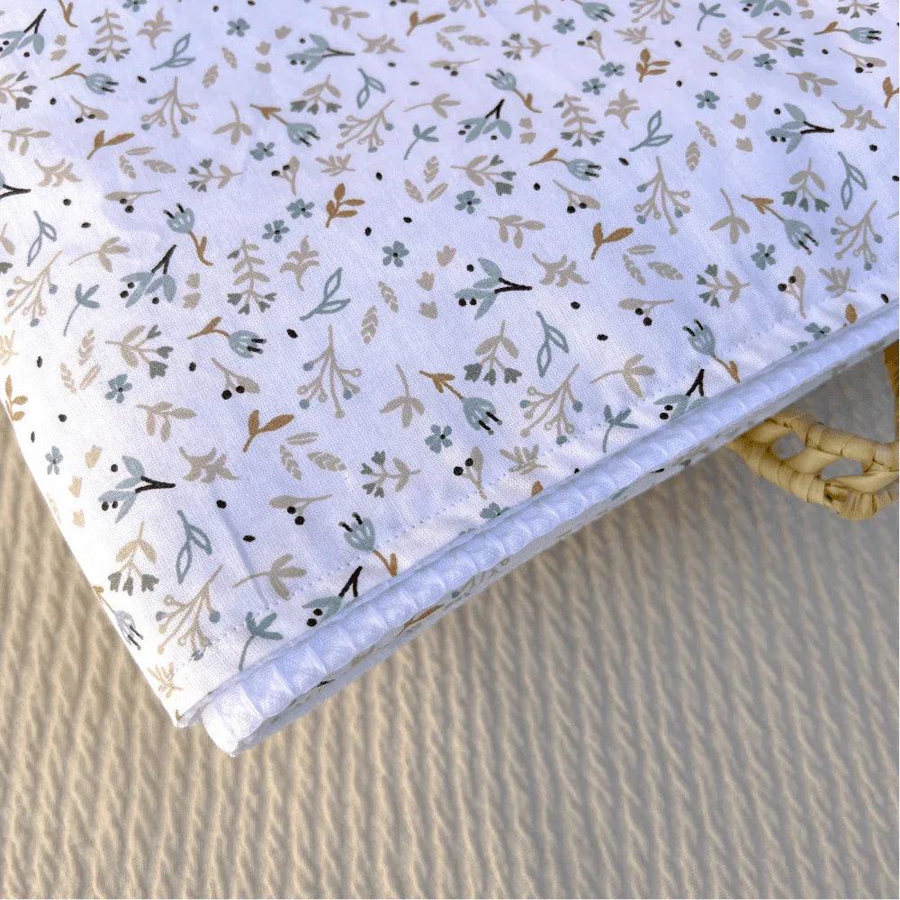 Cotton baby mat with a nature print in soft tones, ideal for baby's comfort and rest.