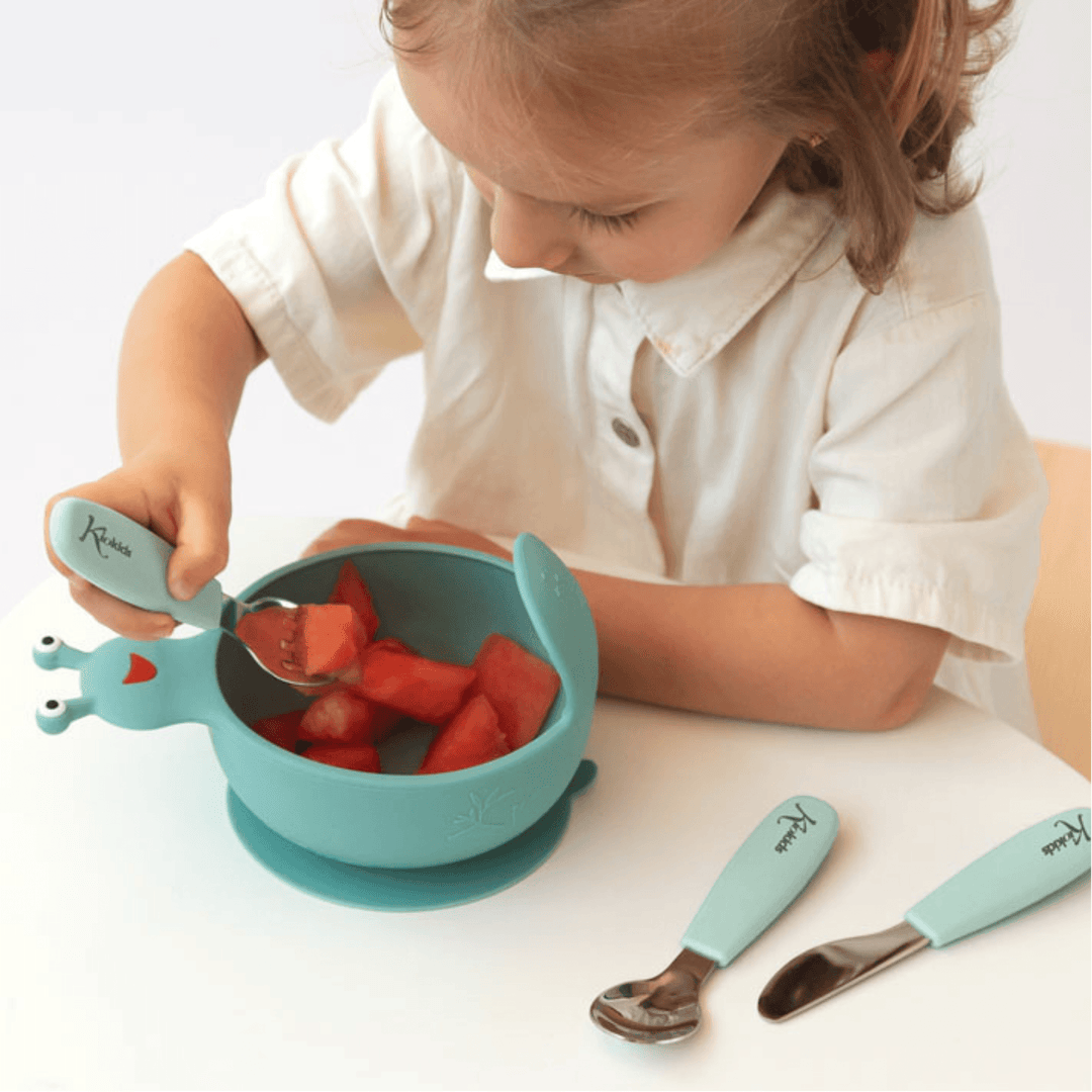 Bambino che usa le posate per bambini KioKids con manico ergonomico