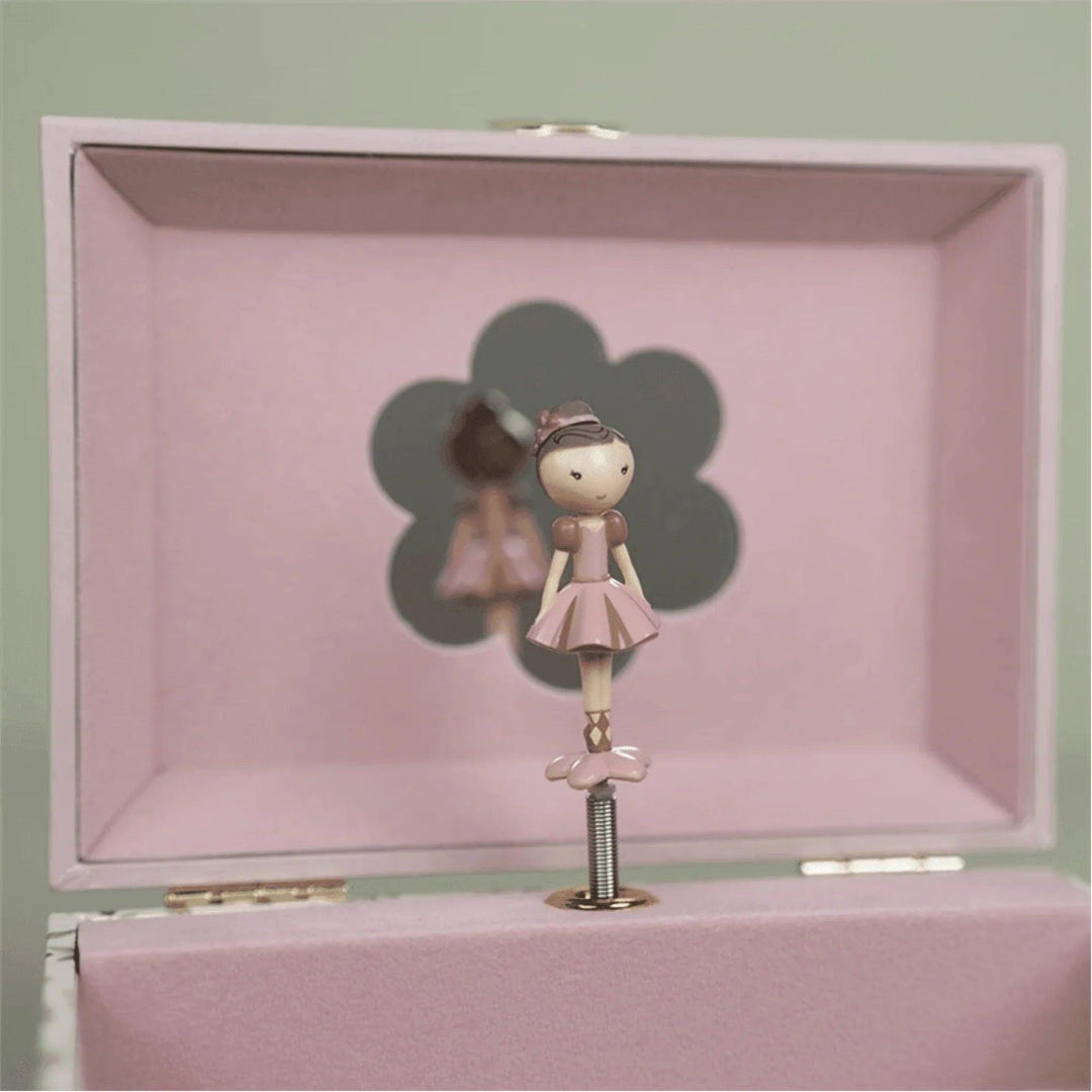 Detalle de la bailarina rosa giratoria en el interior del joyero musical, frente a un espejo con forma de flor