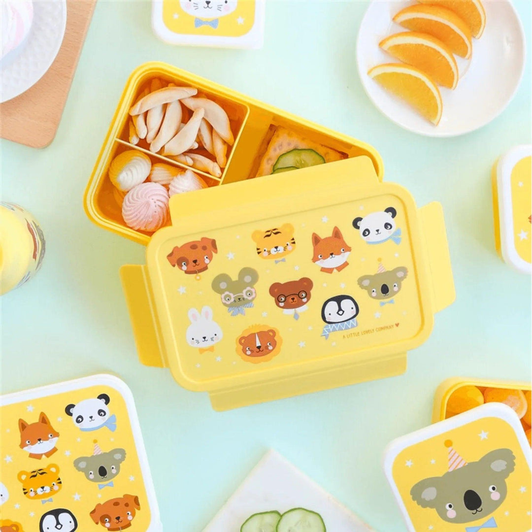 Fiambrera abierta con snacks, dulces y fruta, ideal para niños y uso escolar