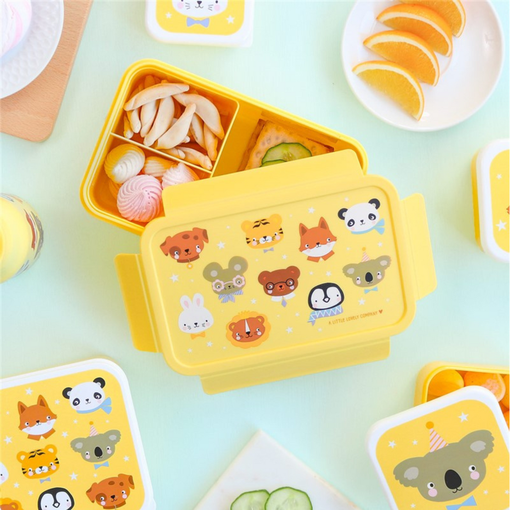 Fiambrera abierta con snacks, dulces y fruta, ideal para niños y uso escolar
