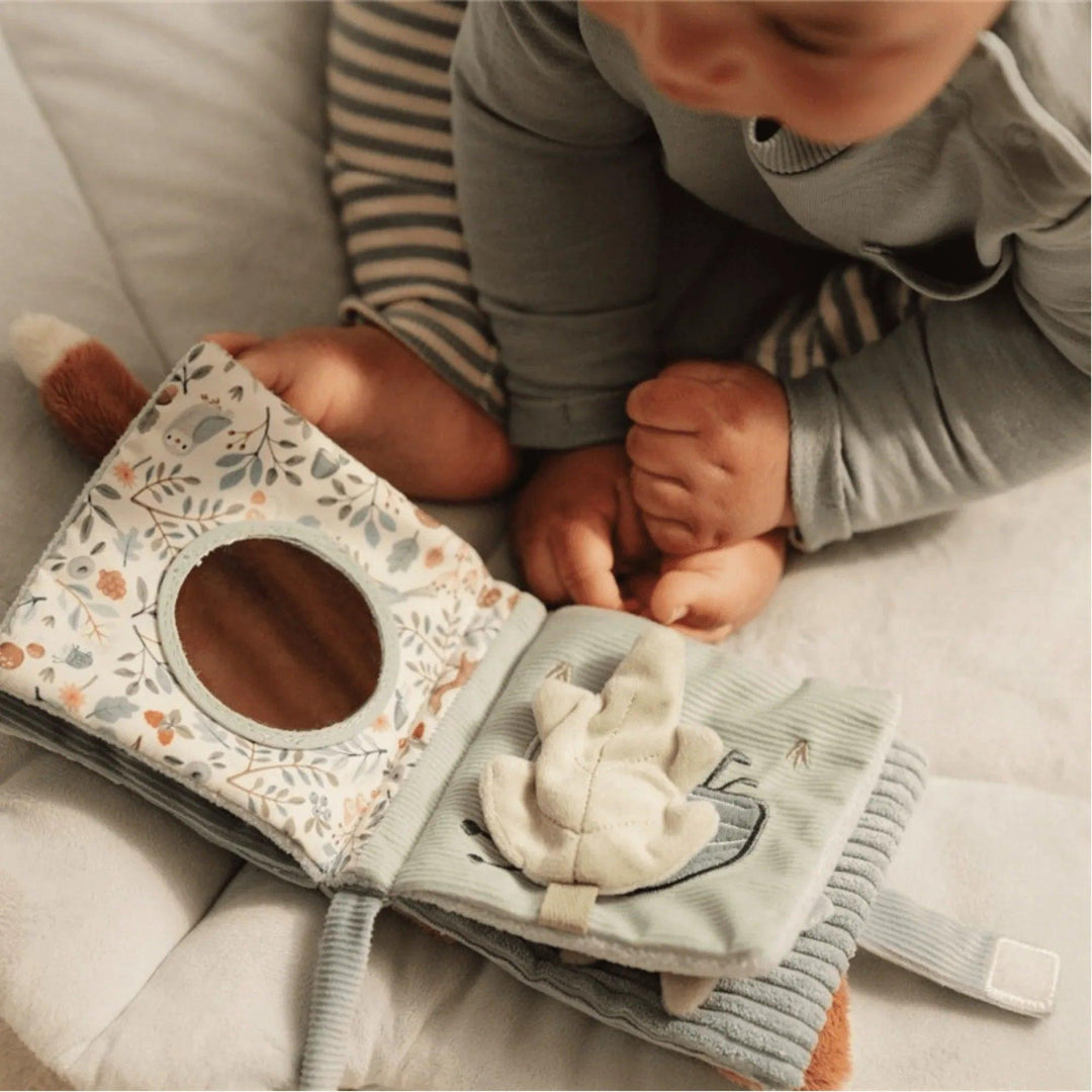Bambino che gioca con il libro sensoriale Little Dutch, libro di stoffa blu con attività tattili e specchio