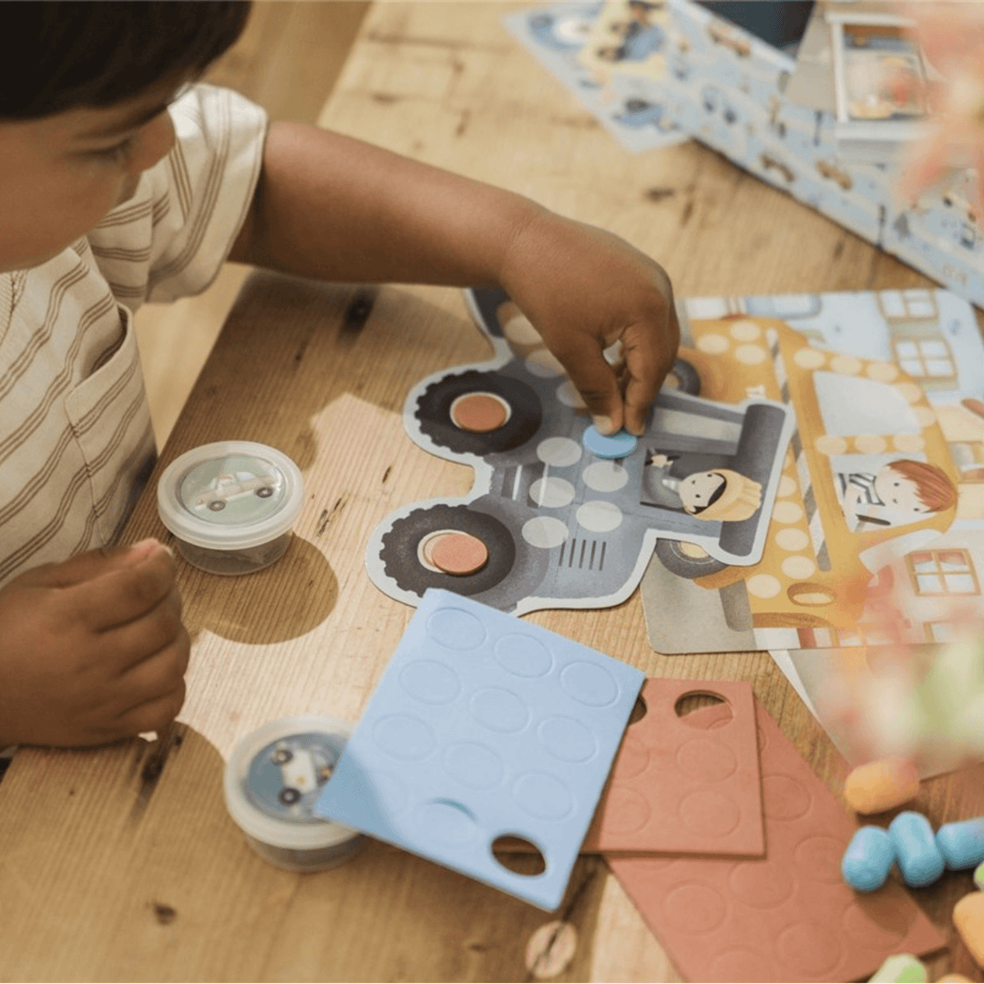 Un garçon joue avec le kit créatif Jim's Creative Box de Little Dutch sur le thème des véhicules