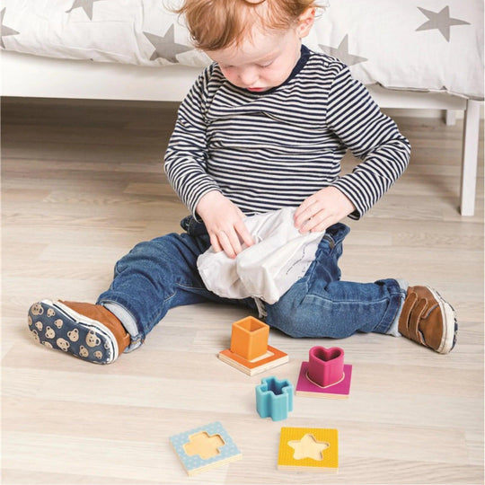 Un tout-petit joue avec un jeu de tri de formes géométriques pour développer sa motricité fine.