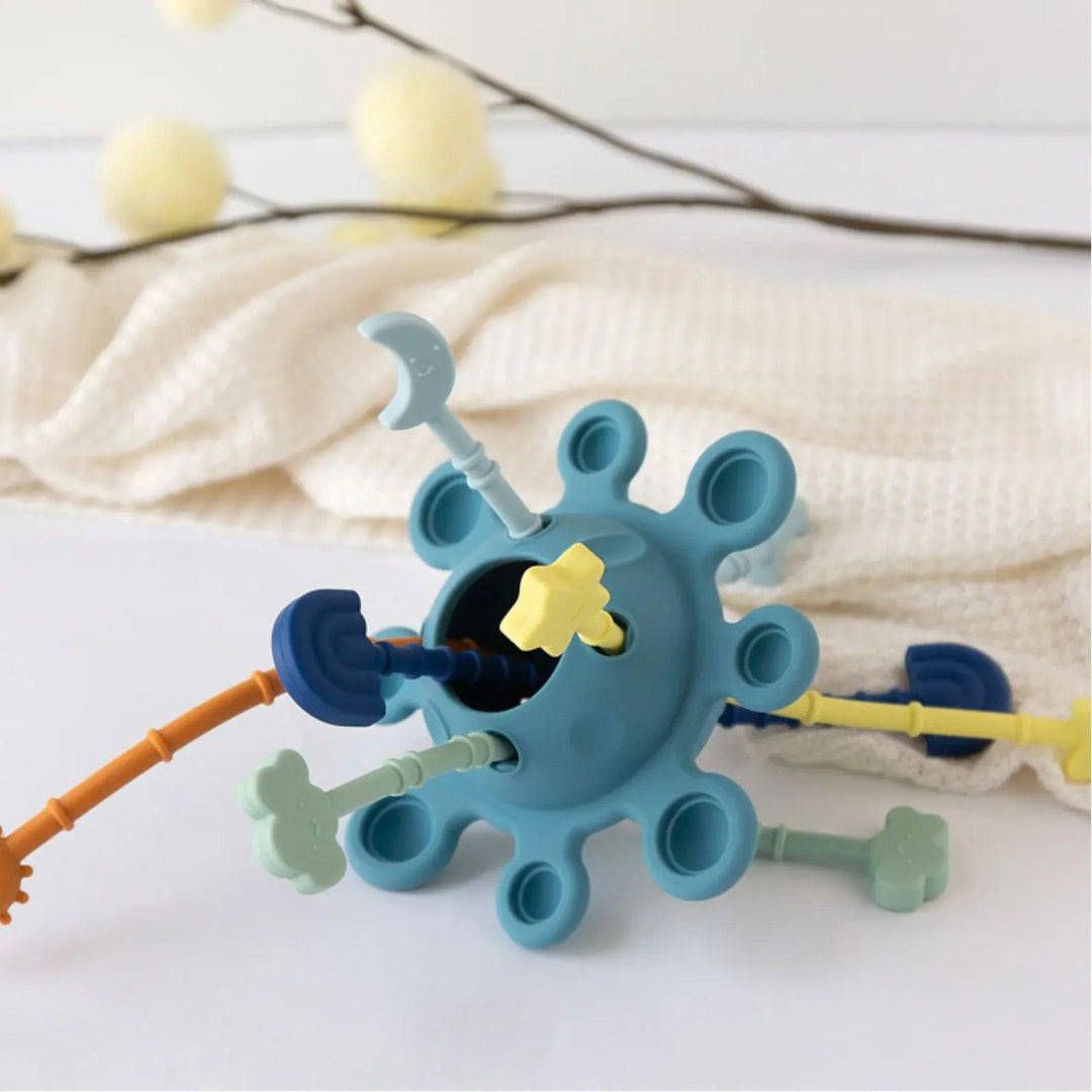 Juguete sensorial de silicona para bebé con varillas texturizadas y colores suaves.