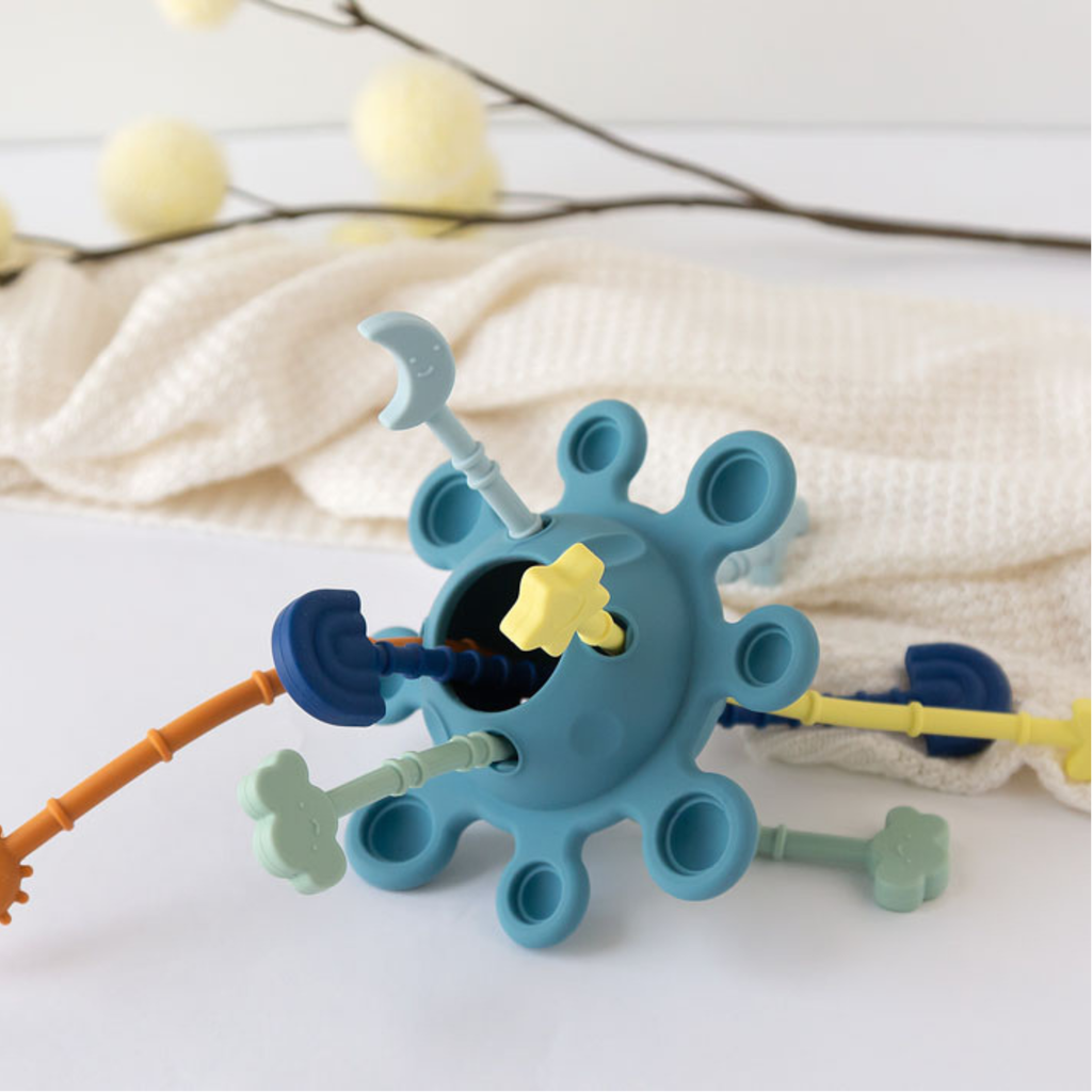 Juguete sensorial de silicona para bebé con varillas texturizadas y colores suaves.