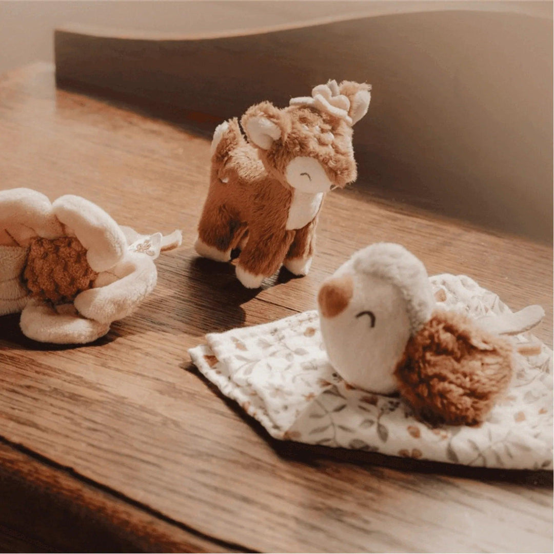 Fabric sensory toys: pink flower, bird, and deer on a wooden table