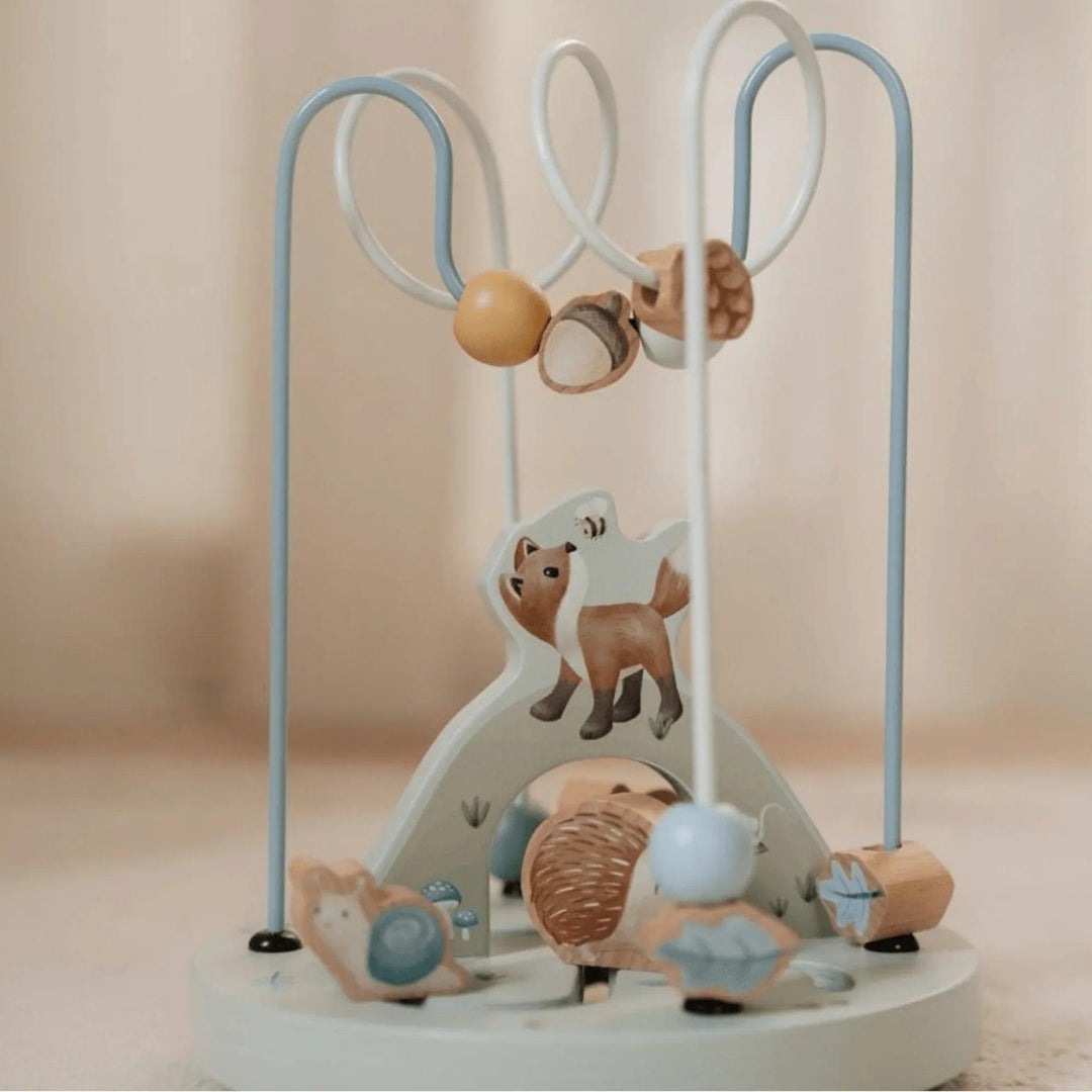 Détail d'un jouet Montessori en bois avec un renard et des pièces mobiles sur un cadre en métal.