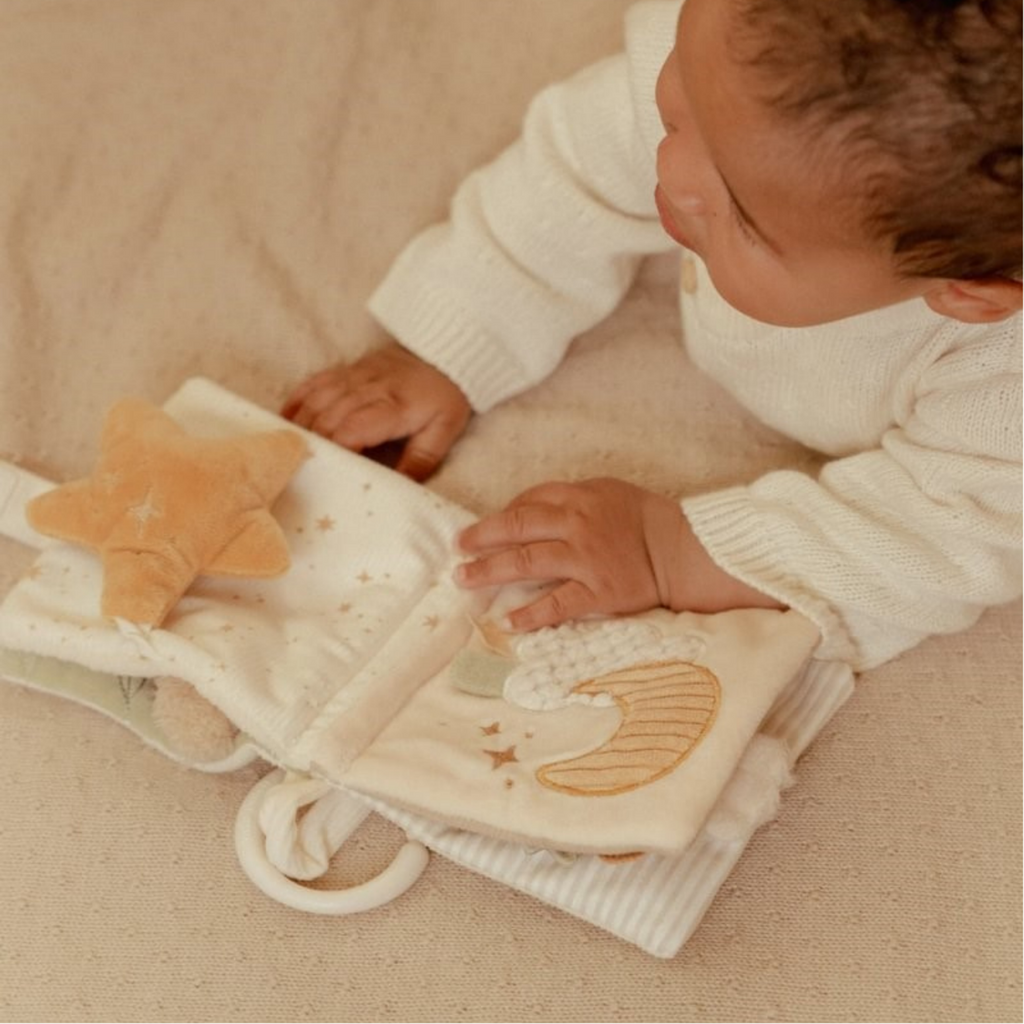Bebé jugando con libro de tela Little Dutch con luna y estrella en tonos suaves