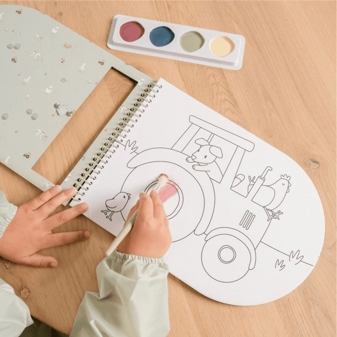 Niño pintando dibujo de tractor en libro de acuarelas infantil Little Dutch Little Farm