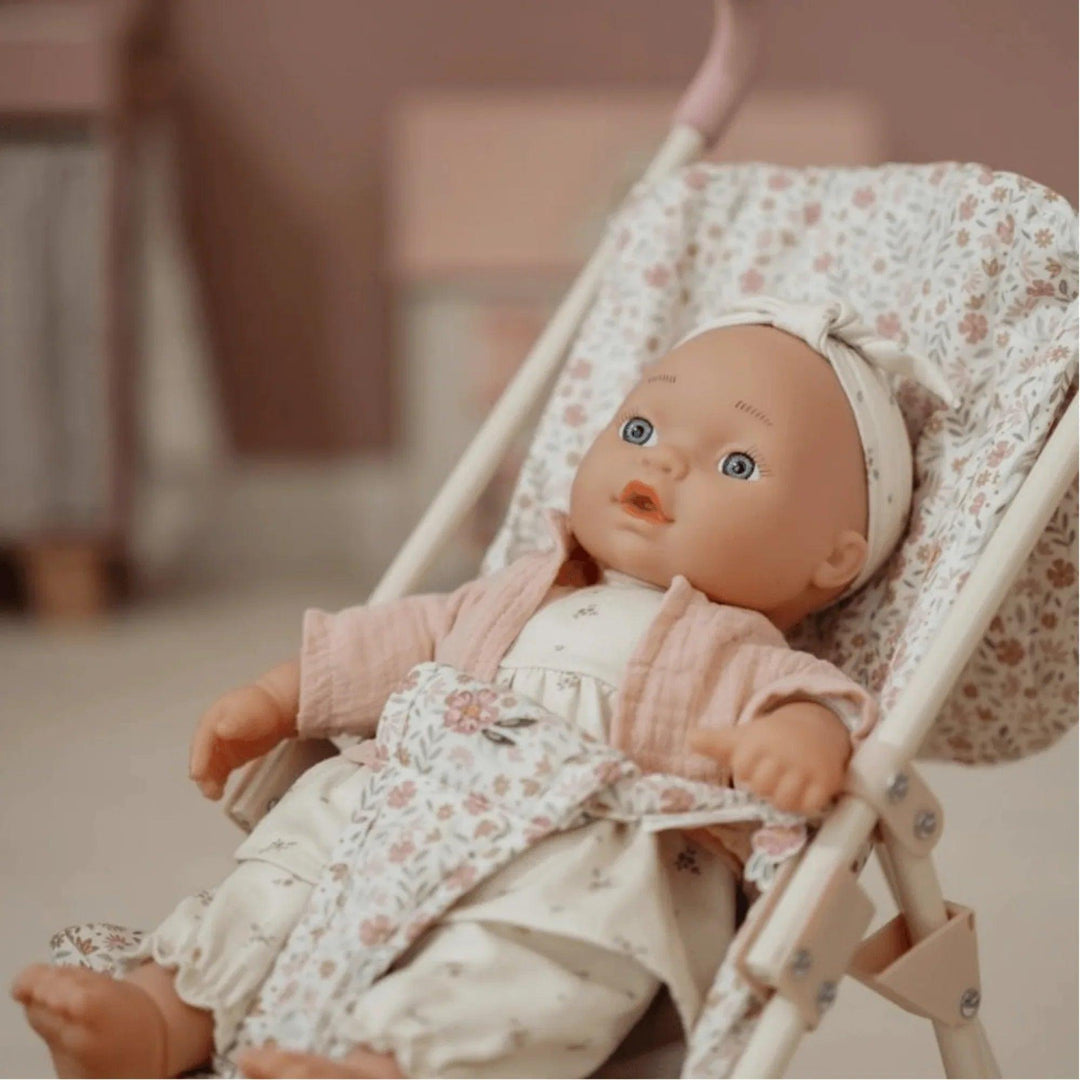Muñeca bebé Little Dutch con chaqueta rosa y carrito estampado de flores, ambientada en habitación infantil