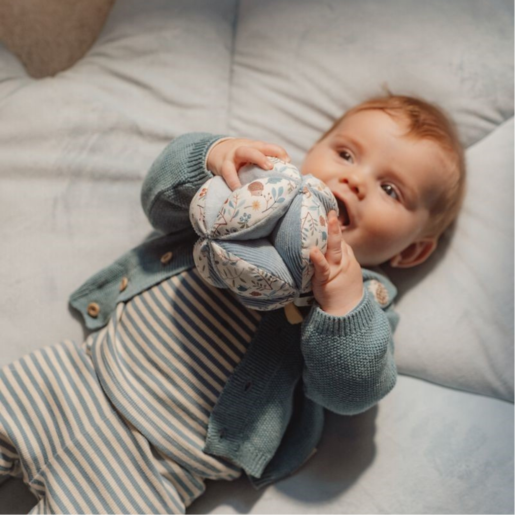 Bebé jugando con la pelota Montessori Little Dutch, ideal para estimular el desarrollo sensorial y la motricidad