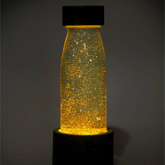 sensory bottle petit boum with yellow light and glowing particles inside