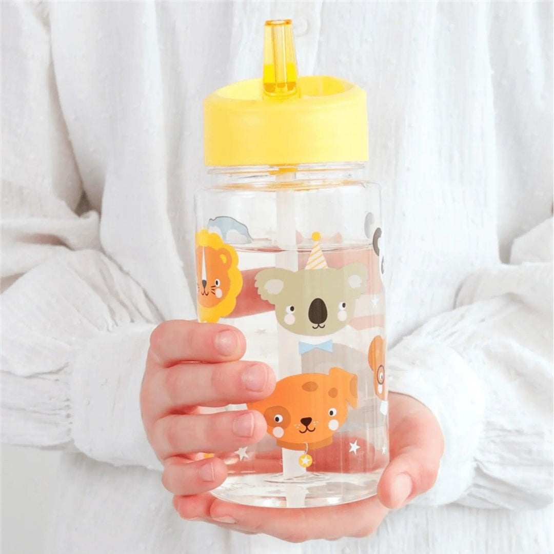 Ragazzo che tiene in mano una bottiglia d'acqua per bambini con tappo giallo e graziosi disegni di animali