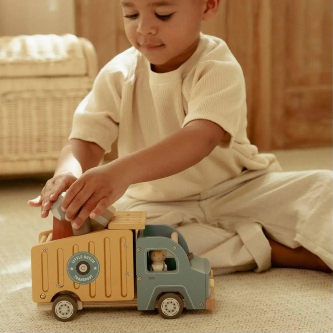 Enfant jouant avec un camion de livraison en bois Little Dutch, plaçant des blocs à l'intérieur du compartiment