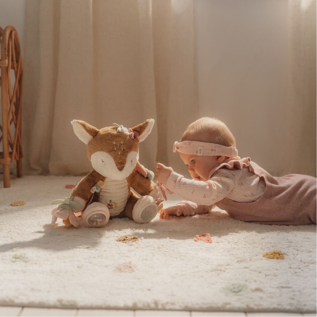 Bebé gateando y tocando el peluche sensorial ciervo con texturas, colores suaves y elementos colgantes
