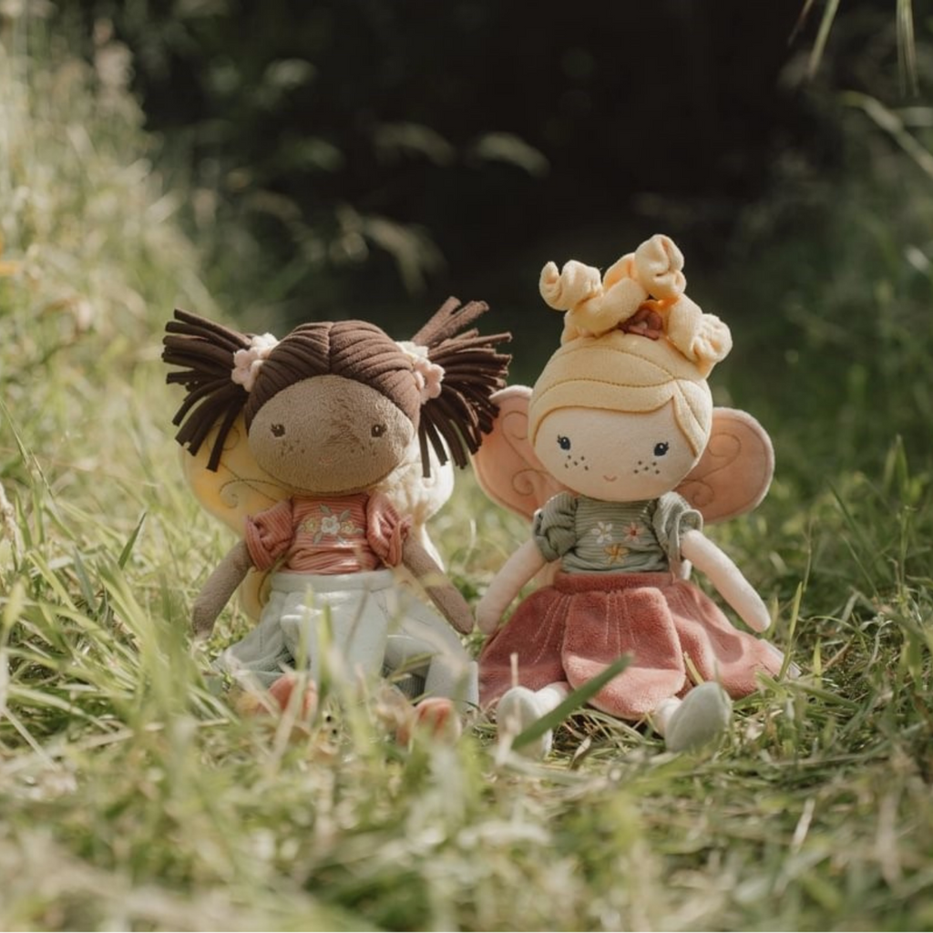 peluches de muñeca en forma de hadas en un fondo rural