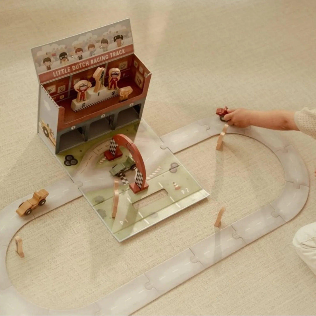 Circuit de course Little Dutch avec virages, arche de ligne d'arrivée et figurines de pilotes en bois.