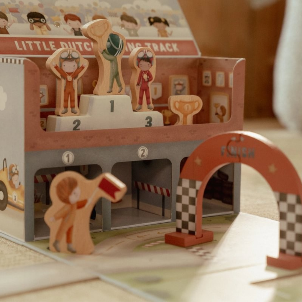 Podio con pilotos y arco de meta del circuito de carreras Little Dutch, fabricado en madera y cartón resistente.