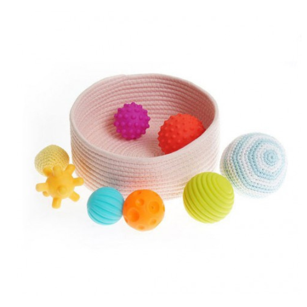 Cesta con bolas sensoriales de distintas texturas y colores diseñada para el desarrollo sensorial del bebé.