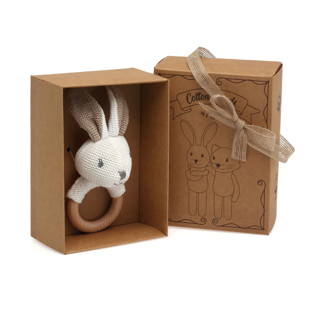 Knitted rabbit rattle for baby presented in a kraft gift box