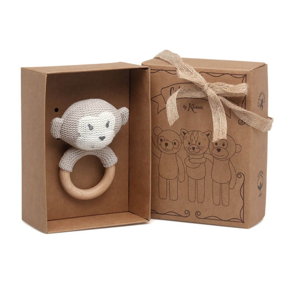 Knitted monkey teething rattle for baby presented in a kraft gift box.