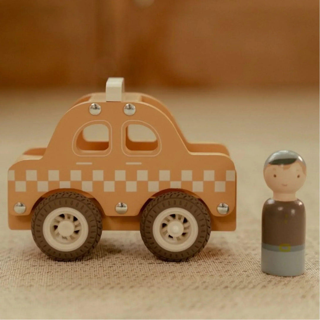 Taxi en bois, jaune avec un motif à carreaux blancs et une figurine de chauffeur Little Dutch sur un tapis beige