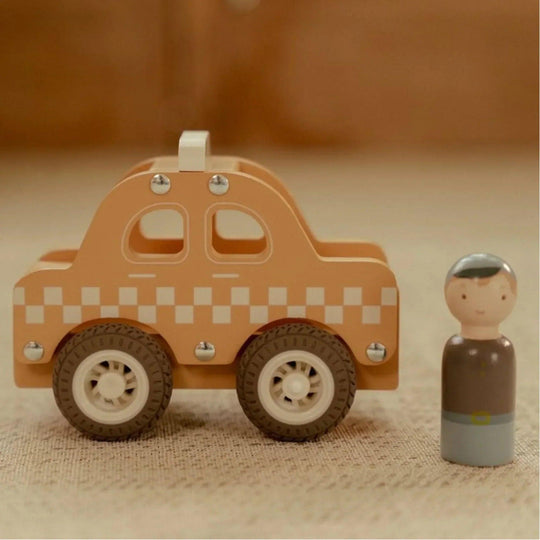 Taxi en bois, jaune avec un motif à carreaux blancs et une figurine de chauffeur Little Dutch sur un tapis beige