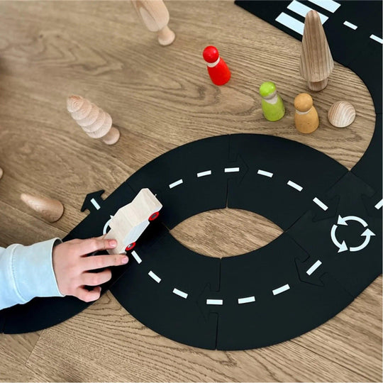 Enfant jouant avec le circuit routier Waytoplay et une voiture en bois