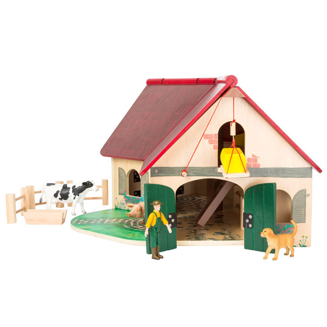 La construcción de madera de la granja juguete está dispuesta en forma de ángulo  y equipada con un techo plegable. 
