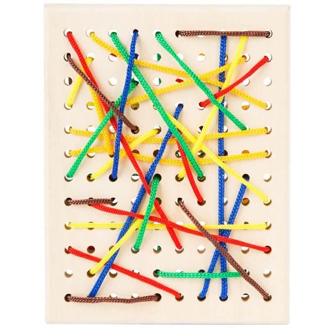 tavola infilafili per fili multicolori. Tavola in legno con fori per infilare fili di diversi colori.