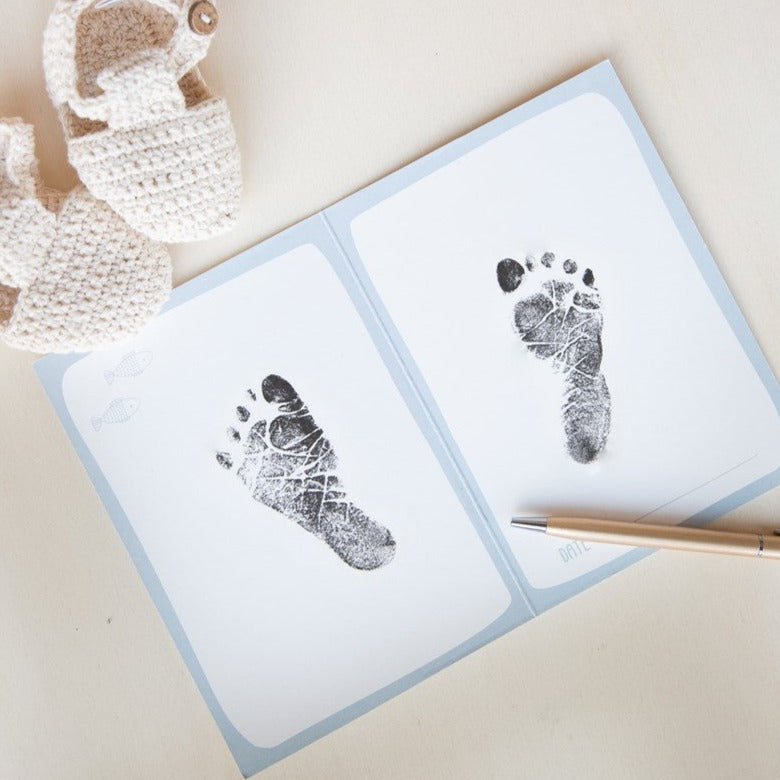 Imprime la huella de tu bebé en la libreta de la caja de recuerdos del recién nacido.
