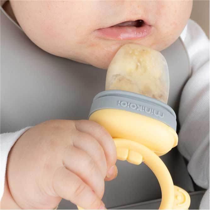 Silicone feeder, in grey and pastel yellow.