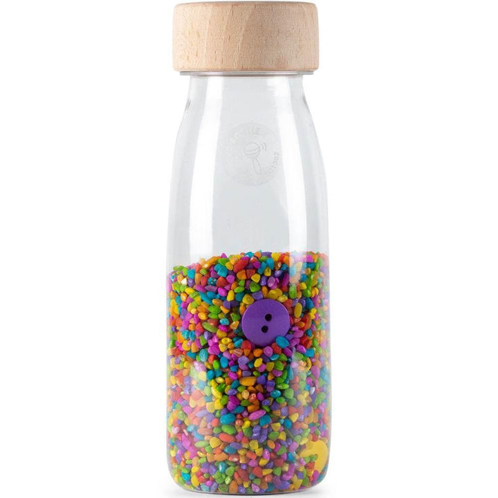 BOUTEILLE SENSORIELLE À BOUTONS SONORES. Aussi simple et efficace que cela. Les petits objets de la série BOUTEILLE SONS SONORES sont un véritable régal pour les tout-petits. L'identification visuelle des pièces à l'intérieur est combinée à une stimulation auditive, particulièrement importante pendant la première année de vie de bébé. Elle l'aide à apprendre à distinguer les sons : du plus faible au plus fort, en associant chaque son à une signification.