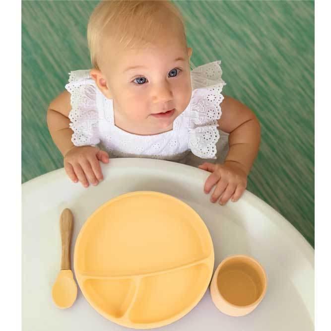 Plato para bebe de silicona con tres divisiones en color amarillo pastel.